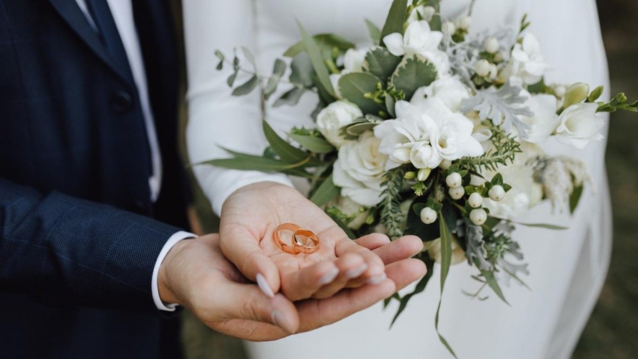072851600_1672970832-wedding-bands-hands-bride-groom-with-beautiful-wedding-bouquet-made-greenery-white-flowers_1_.jpg