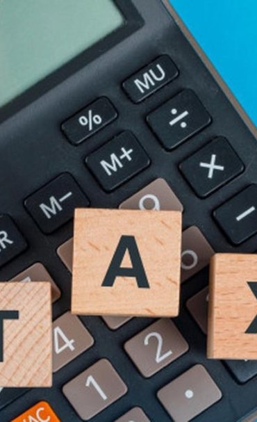 044002400_1614227023-tax-planning-concept-with-wooden-cubes-calculator-blue-table-flat-lay_176474-9519.jpg